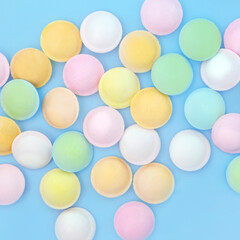 Flying saucer UFO sweet sherbet food abstract background on blue. Old fashioned confectionery fun multicolored fizzy candy treats.
