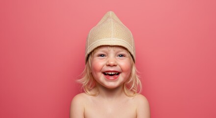 Adorable little girl beaming with joy wearing traditional sauna hat on vibrant pink background
