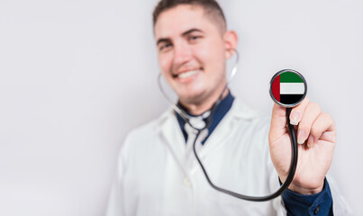Doctor showing stethoscope with United Arab Emirates flag. United Arab Emirates national healthcare concept