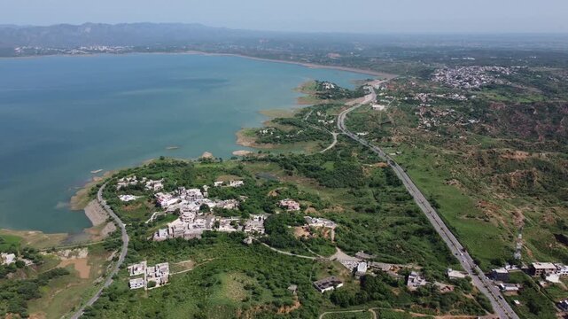 Panoramic drone view of Mangla Dam lake, showcasing its vast blue waters, surrounding landscapes, and Mirpur Ccity.