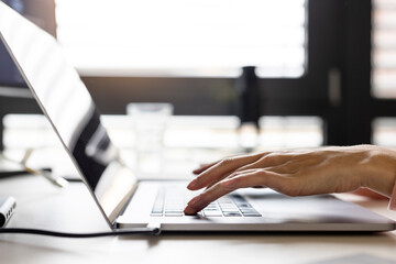 Hands of businesswoman typing on laptop