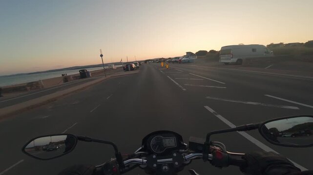 Motorbike driving at the beach at sunset