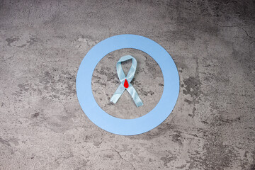 Light Blue Awareness Ribbon With Decorated Blood Drop And Diabetes Symbol On Grey Texture Background