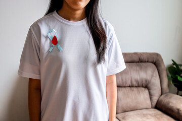 Close Up Woman Wearing A Diabetes Awareness Ribbon With Red Drop On White Shirt