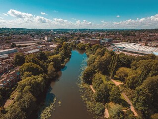 Aerial view of a river winding through a green, urban landscape on a sunny day