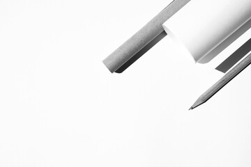 Fototapeta premium Layout of Paper Rolls, Graphite Crayon on White Desk. Architect Design Studio. 