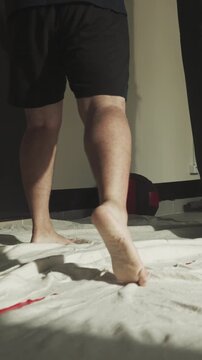 Kick-boxers exercises with punching bags in gym closeup. Barefoot athlete trains with friends on carpet in fighting club slow motion. Body and mind power