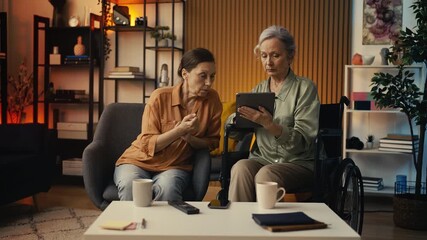 Woman with disability helping female friend create online account using tablet