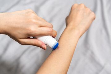 Apply itchy liquid to mosquito bites with one hand