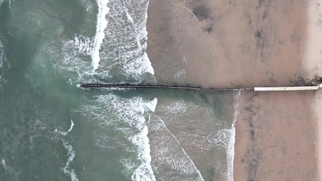 aerial shot of waves and beach at mexico us border in tijuana