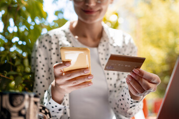 Woman making online payment using smartphone and credit card