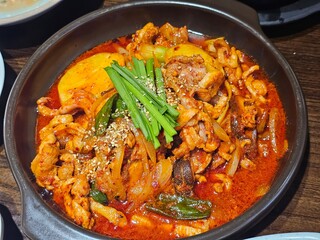 Spicy stir-fried duck dish with vegetables, served in a hot pot. A traditional Korean delicacy seasoned with red chili paste and sesame seeds.