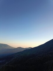 Obraz premium Sunrise Over Misty Hills and Green Valleys