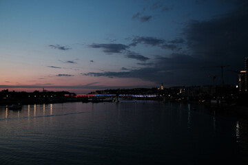Obraz premium Scenic view of illuminated bridge and Saint Michaels Cathedral at dusk in Belgrade, Serbia. Reflections in calm river.