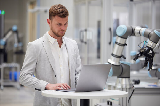 Businessman using laptop on table in modern factory