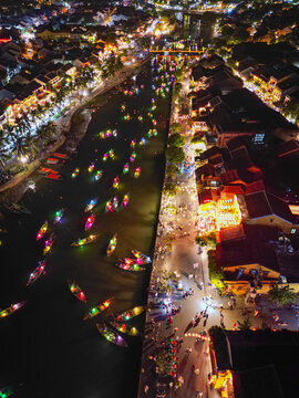 Aerial view of boats adorned with colorful lanterns glide along the river, reflecting the vibrant lights of the ancient town, H&aacute;&raquo;&trade;i An, Qu&aacute;&ordm;&pound;ng Nam, Vietnam.