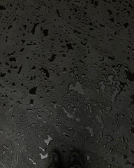 voluminous water drops on new black asphalt view from above on feet. rainy asphalt under feet
