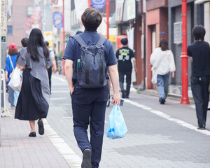 夏の都市の商店街で歩く人々の姿