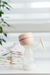 Baby Clothes Stack with Breast Pump and Toy. Baby care.