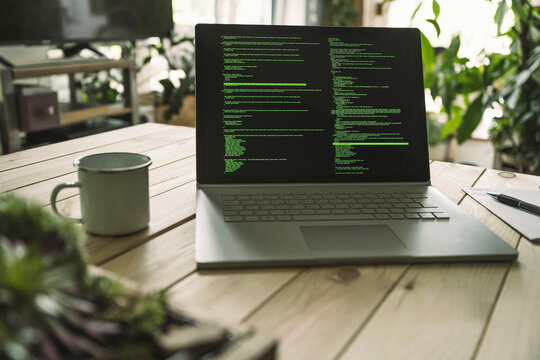 Computer coding language on laptop screen at home office