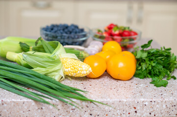 Fresh vegetables and berries on kitchen counter in natural light
