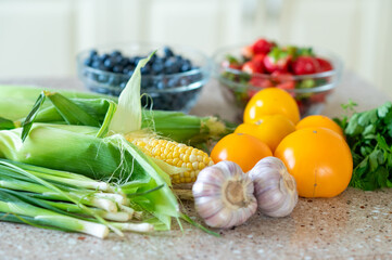 Fresh vegetables and berries on kitchen counter in natural light