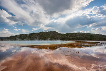 Obraz premium A wide shot of the Grand Prismatic Spring in Yellowstone National Park, Wyoming, showcasing its vibrant colors and the surrounding landscape.