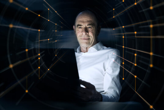 Businessman using laptop amidst illuminated dots at office