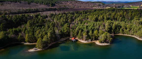 Drone view of Loch in Scotland with Boathouse and Woodland 