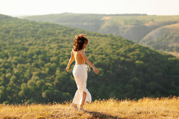 A peaceful moment of a woman in an elegant dress, surrounded by greenery and warm sunlight streaming through