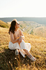 A woman revels in the tranquil beauty of nature, embracing and capturing the warm colors of a beautiful sunset