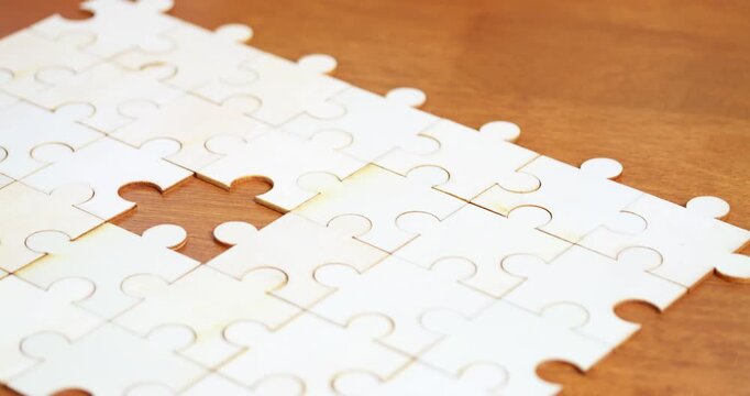 A close-up view of hands placing the final piece of a jigsaw puzzle symbolizing achievement and focus.
