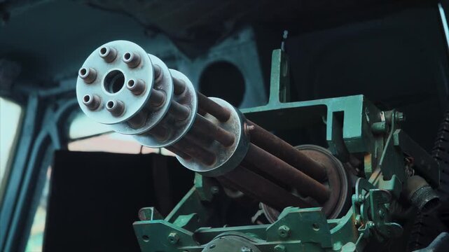 Close-up shot of a mounted Gatling-style rotary machine gun barrels inside a military vehicle or aircraft