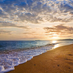 sandy sea beach at the dramatic sunset