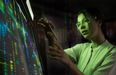 Confident businesswoman wearing smart glasses examining big data on screen at office