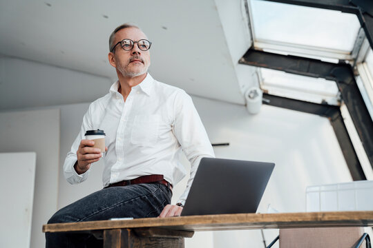 Thoughtful architect with disposable cup at start up office