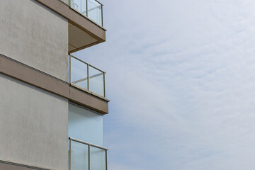 Balcon moderne d'un immeuble contemporain sous un ciel nuageux.