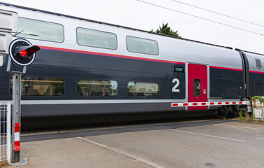 Train à deux niveaux circulant avec un signal d'arrêt visible rouge.