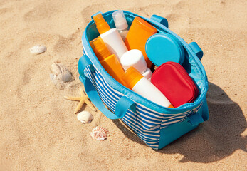 A beach-ready cosmetic bag overflowing with various sunscreens, moisturizers, and after-sun creams, all resting on golden sand. Perfect for highlighting sun protection essentials