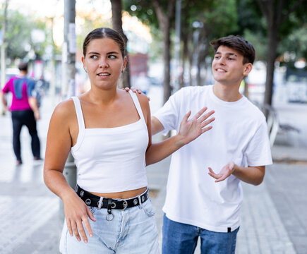 Confused woman rejecting annoying young man trying to acquaint with her.