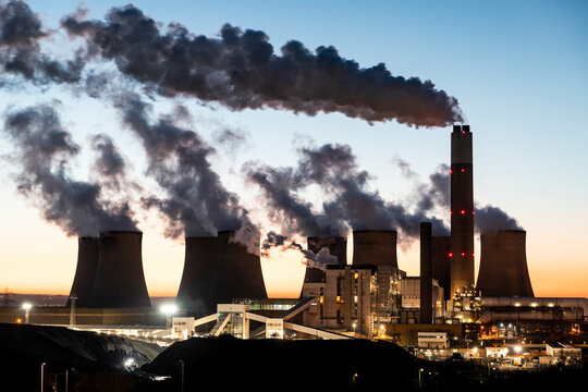 UK, England, Nottingham, Water vapor rising from cooling towers of coal-fired power station at dusk