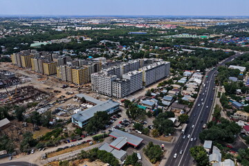 Fototapeta premium Construction of multi-storey buildings. One of the central streets of the city. The view from the drone.