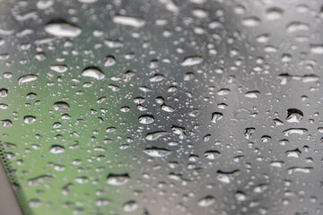 close-up, full-frame shot of numerous water droplets of varying sizes clinging to a glass surface