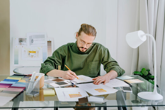 Furniture designer drawing sketch of chair sitting at desk in office