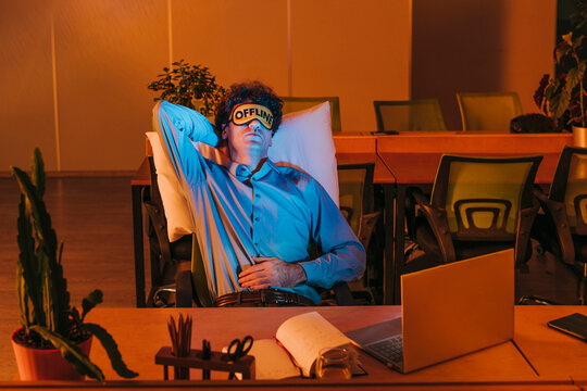 Businessman wearing eye mask and sleeping in office