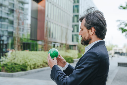 Businessman solving puzzle sphere at office park