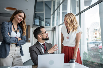 Business team discussing strategy in modern office with laptop