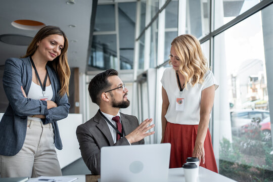 Business team discussing strategy in modern office with laptop