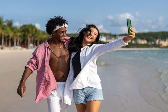 Interracial couple enjoying a romantic beach getaway, embracing love, laughter, and togetherness