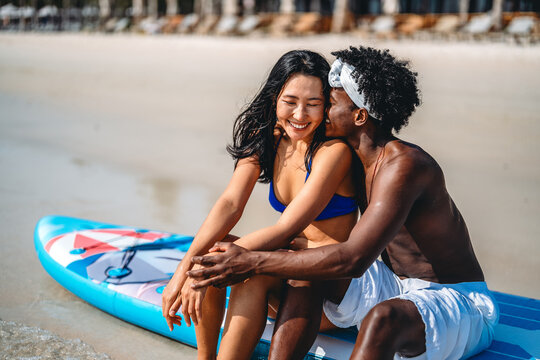 Interracial couple enjoying a romantic beach getaway, embracing love, laughter, and togetherness